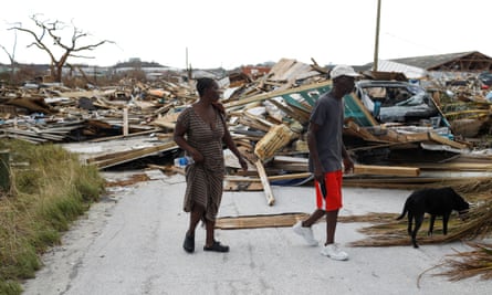 People walk among debris at the Mudd neighborhood, devastated after Hurricane Dorian hit.