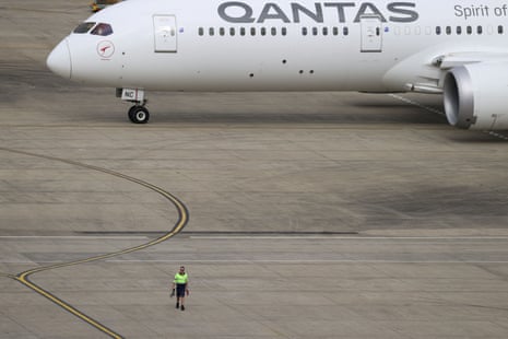 A ground worker walking near a Qantas plane at Sydney airport