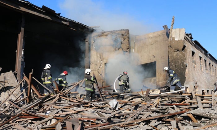 Firefighters working to put out a fire after shelling at an industrial building in Kharkiv region.