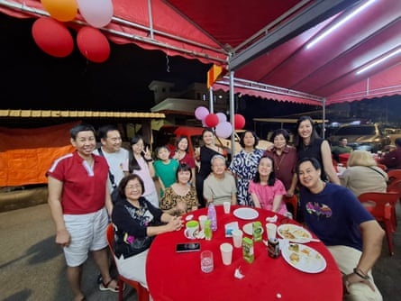 Kam and Francis Chen with family around a red table