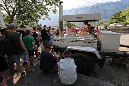 People line up for meals at a field kitchen in Massandra, Crimea