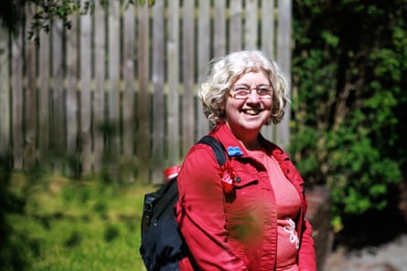 A woman in a red jacket and pink T-shirt smiles at the camera