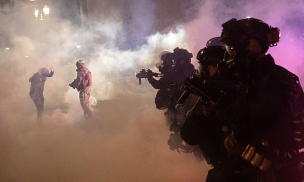 Federal law enforcement officers fire tear gas and other munitions to disperse protesters in Portland Wednesday night.
