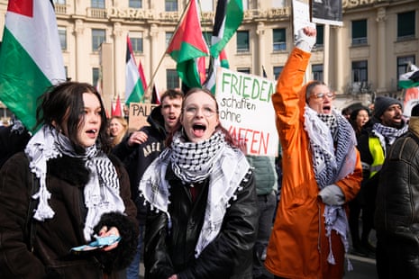 Protesters shout slogans in a protest against the Munich Security Conference in Munich, Saturday, Feb. 15, 2025. Central poster reads: 'Make peace without weapons’.