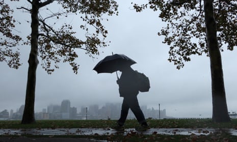 A person walks in the rain during the nor’easter in Hoboken, New Jersey, on 26 October. 