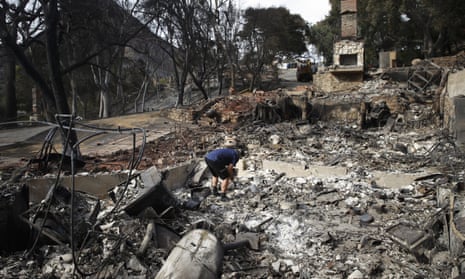 Roger Kelton searches through the remains of his mother-in-law’s home leveled by the Woolsey Fire, in Agoura Hills, near Cornell, California.