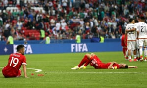 The Russian players are dejected whilst the Mexican players celebrate.