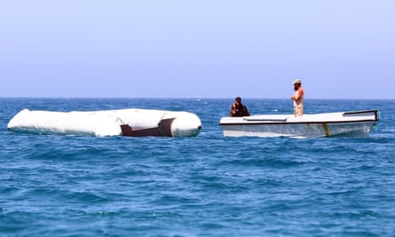 A Libyan coast guard vessel drags a deflated rubber boat after the craft sank off Garabulli on 10 June 2017.