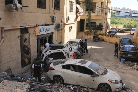 People clear the debris at the site of an Israeli strike on Beirut's southern suburbs.