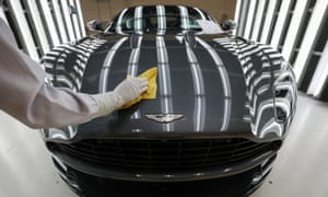 An employee polishes the bodywork of an Aston Martin DB11