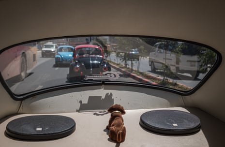 The view out of the rear window of a VW Beetle driving through Addis Ababa, with members of City Cruise following behind