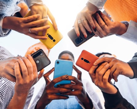 Young adults in a circle holding smartphones