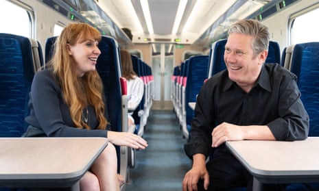 Keir Starmer and Angela Rayner sitting across the aisle from each other on a train