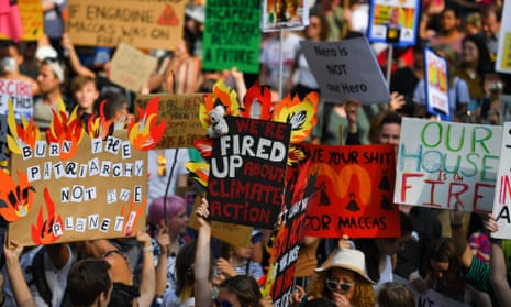 Protesters hold placards at a climate rally in Sydney on Friday