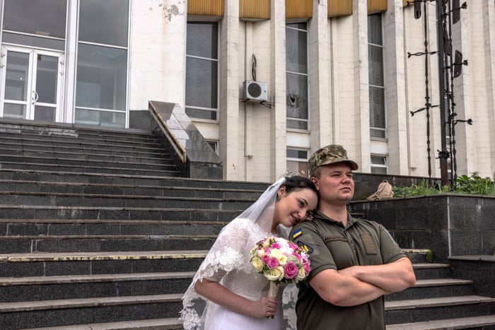 Life continues in Kyiv as Ukrainian serviceman Vladyslav, 26, and his bride Valentyna, 24, pose for photos after their wedding ceremony.