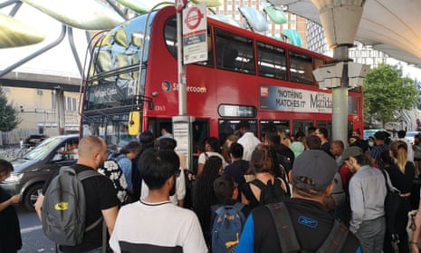 People queue for a bus in Stratford as London transport strike begins.