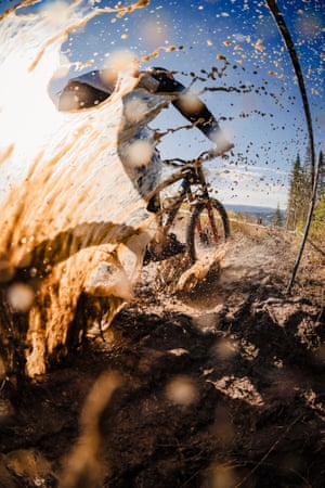 A shot from behind and close to the ground as a bike rider travels past, throwing up mud