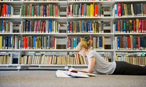 Caucasian woman studying on floor of library