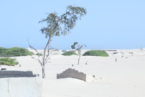 The remains of buildings dot a desert landscape