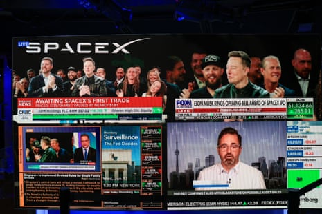 SpaceX CEO Elon Musk, joining remotely from company headquarters in Starbase, Texas, is displayed on monitors.