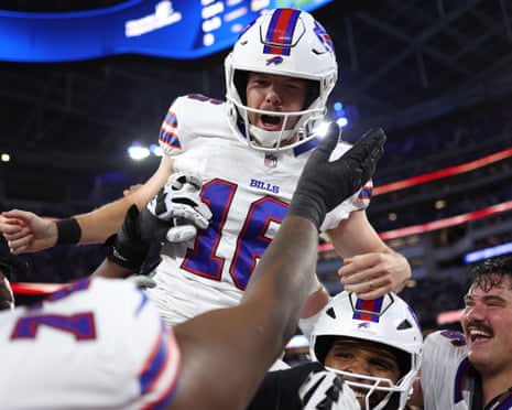Tyler Bass is lifted up by teammates, celebrating a game-winning field goal