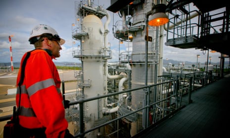 A worker crosses a walkway at a plant at the Queensland Curtis Liquefied Natural Gas plant