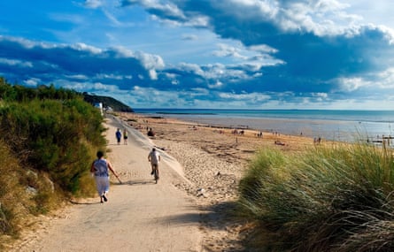Long sandy beach and people on path