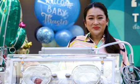 Paetongtarn Shinawatra next to an incubator containing her newborn baby during a news conference in Bangkok