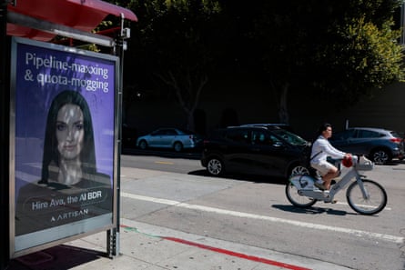 A person bikes past an AI sales agent advertisement in San Francisco, California.