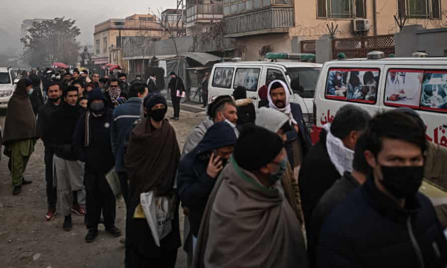 People queue to enter the passport office at a checkpoint in Kabul