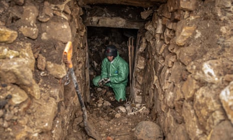 A volunteer of the group called the Black Tulip, at work extracting two rotted Russian corpses from a cellar next to a destroyed house.