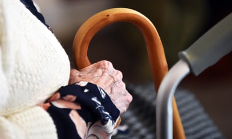 A hand holding a walking stick in a care home