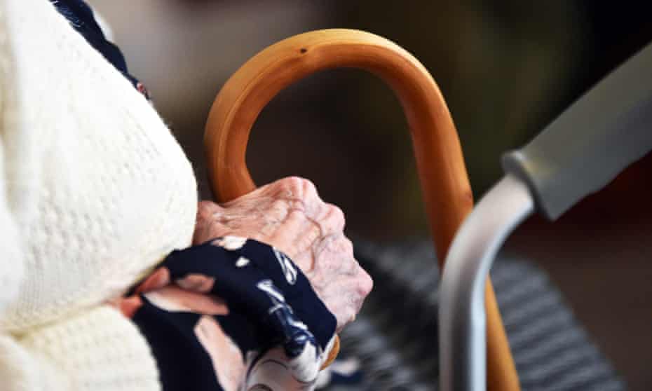 Close-up of an elderly woman's hand holding her walking stick in a care home.