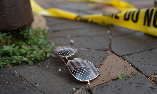Police crime tape is seen near a pair of American flag-themed sunglasses on the ground at the scene of the Fourth of July parade shooting in Highland Park, Illinois.