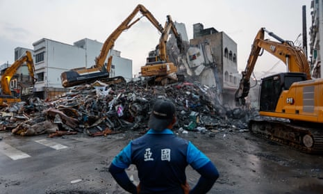 A worker watches excavators demolish the wreckage of a collapsed residential building following the earthquake in Hualien, Taiwan, on Thursday.