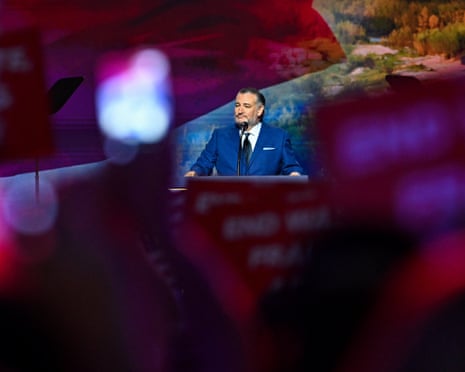 flags and signs from the audience surrounding a man speaking at a podium