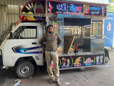 A man leans against a small van being converted into an ice-cream truck