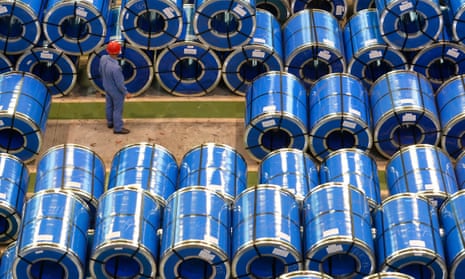 A worker examines rolls of steel at a plant in Taiyuan, China