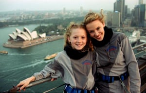 Singer Kylie Minogue and young Olympic opening ceremony star Nikki Webster stand together on top of the Sydney Harbour Bridge.
