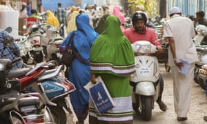 Bohra Muslim women, in their traditional and colorful two-piece dress called rida, walk near the Raudat Tahera mausoleum in central Mumbai