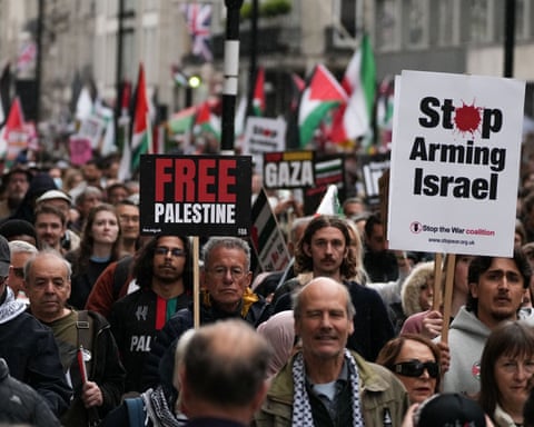 Protesters holding up signs saying 'Free Palestine' and 'Stop Arming Israel'