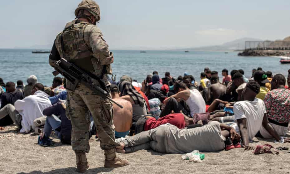 A Spanish soldier looks at people who have swum over the border from Morocco into Ceuta on Tuesday