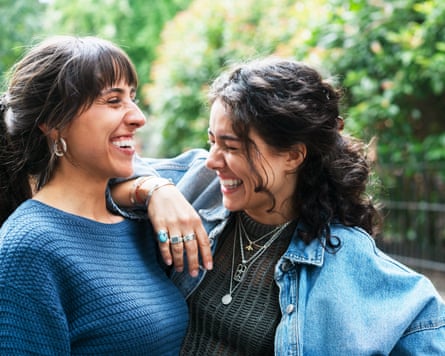 Woman smiling and leaning connected her friend’s shoulder