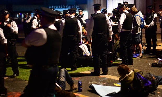 Police remove Extinction Rebellion demonstrators from Waterloo Bridge in London on Sunday night. 