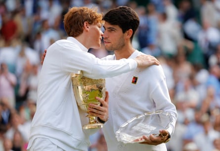 Jannik Sinner and Carlos Alcaraz embrace after the trophy presentation.