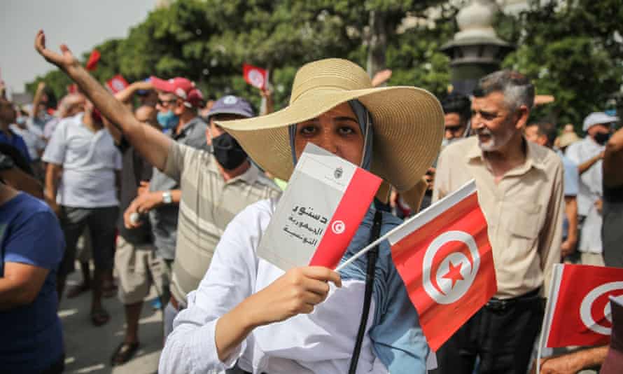 A young woman holds a copy of the 2014 Tunisian constitution at a demonstration in Tunis
