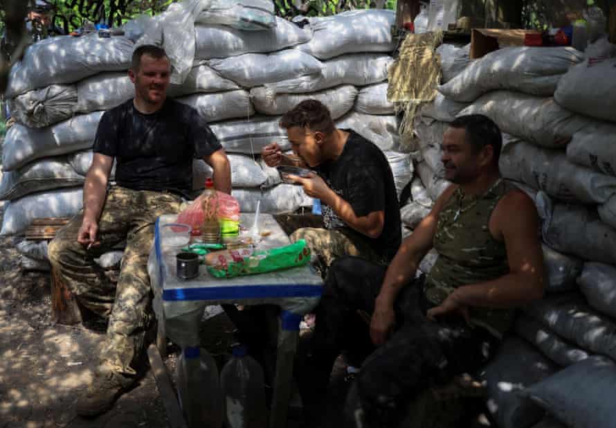 Ukrainian service members eat at a position on the front line in the Donetsk region, Ukraine.