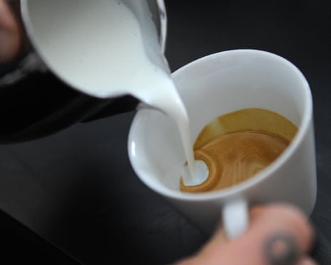 A barista pouring a cup of coffee