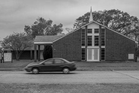 A car drives past a church.