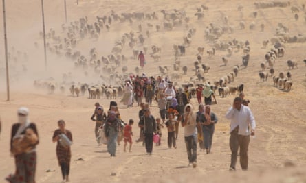 In August 2014, displaced Yazidis flee violence from forces loyal Isis in Sinjar town, heading for the Syrian border